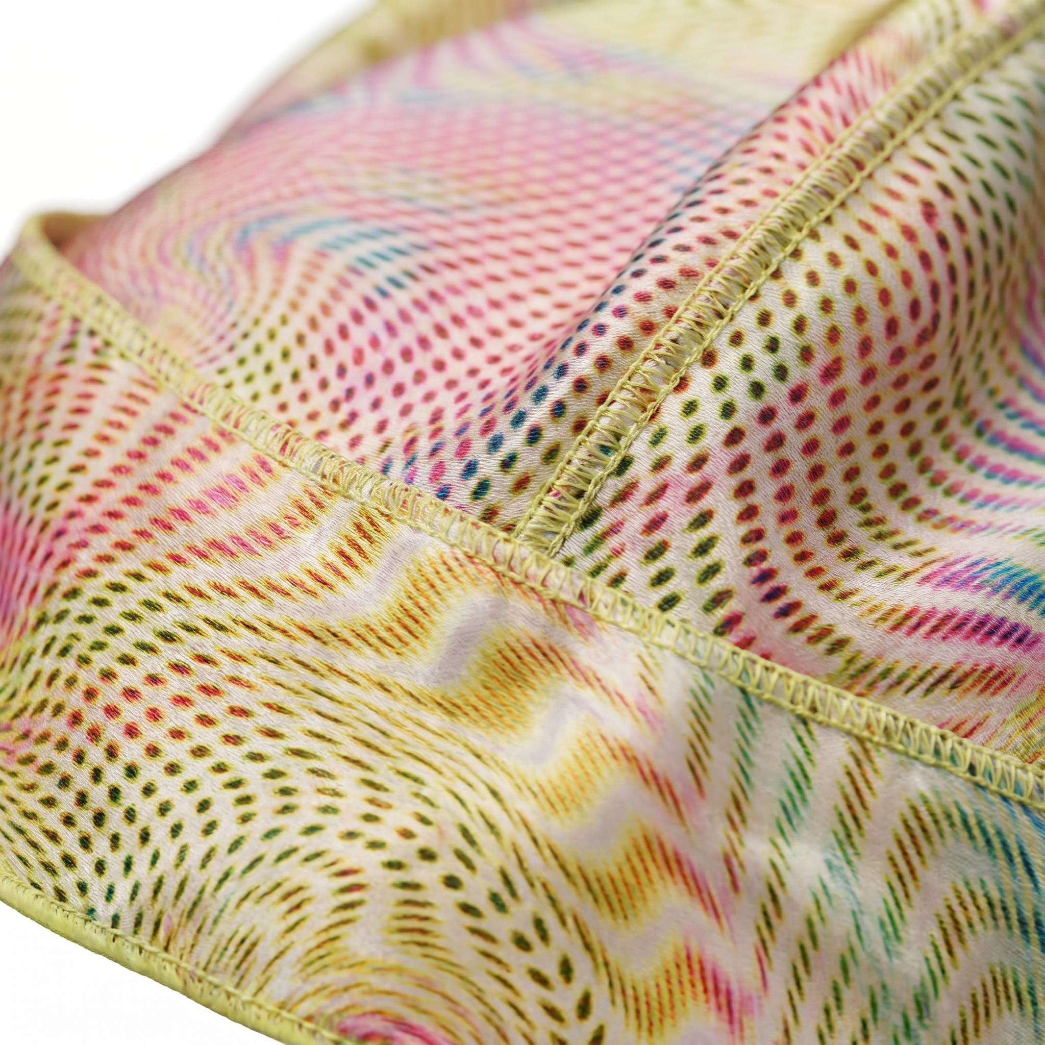 Warm-tone optical illusion swirl Satin Silky Durag fabric close-up showing Warm-tone optical illusion swirl print and stitching detail