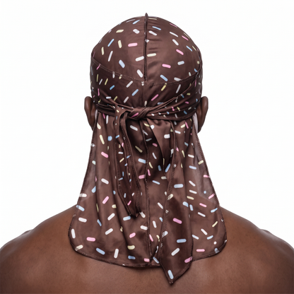 Dark brown ice cream sprinkle Satin Silky Durag worn by male model, back view showing tied wrap and tail